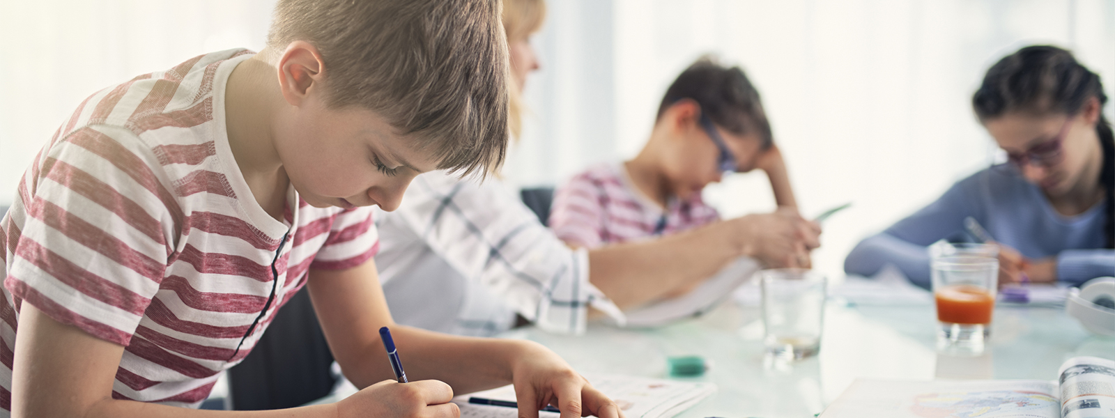 parent and children working on homework together at the kitchen table