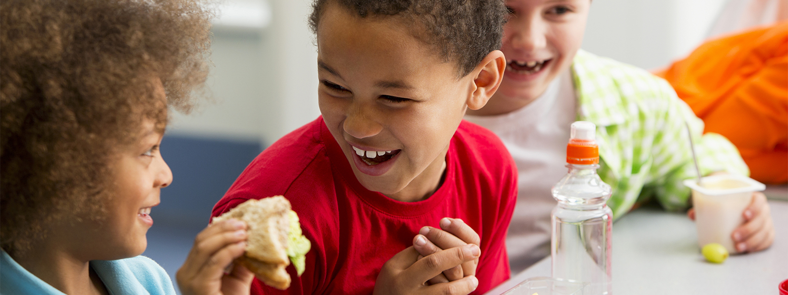 group of young students enjoying lunch and laughing